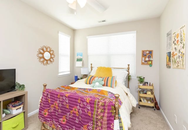 Bed with colorful throw and yellow pillows bedroom at Varsity Club in Clemson Student Accommodation